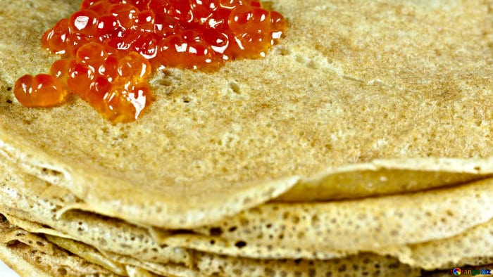 Blini are served with salmon eggs or sour cream.