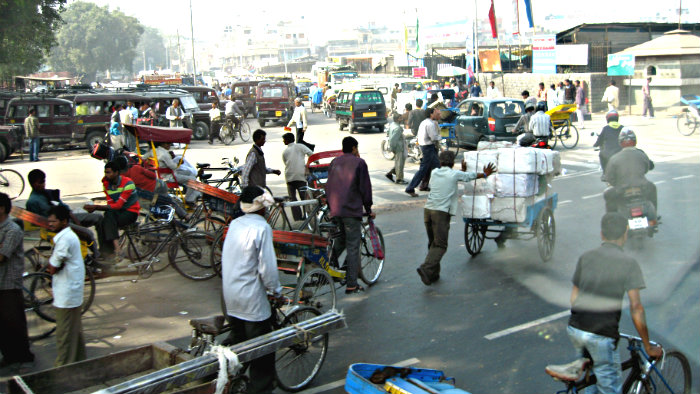 Buses, cars, rickshaws, beasts of burden, cows, dogs share the same road.