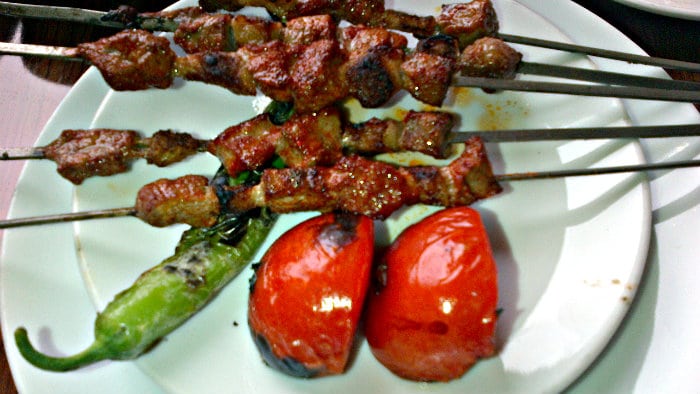 Lamb kebabs are prepared on skewers over the fire.